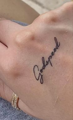 a woman's hand with a small tattoo on it that reads, love you