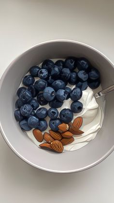 a bowl filled with blueberries and yogurt on top of a white table