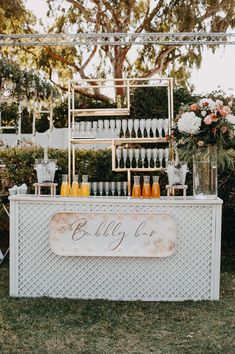 an outdoor bar set up with bottles and glasses