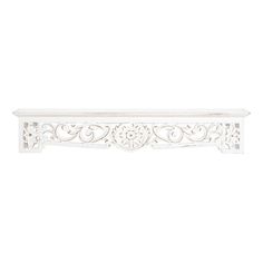 a white shelf with ornate carvings on it's sides and an openwork design at the top