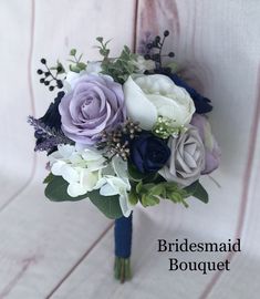 a bridal bouquet with purple, white and blue flowers on the end of it