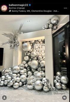 a bunch of silver christmas balls in front of a door with the number 50 on it