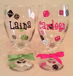 three wine glasses with different designs on them sitting next to each other, one has a pink ribbon and the other is green