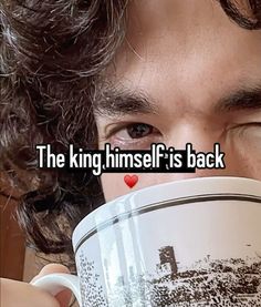 a man holding a coffee cup with the words the king himself is back