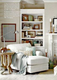 a living room filled with furniture and bookshelves next to a white fire place