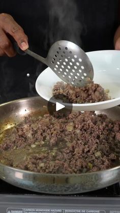 a person cooking food in a pan on top of the stove with a spatula