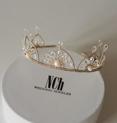 a gold tiara with pearls on it sitting on top of a white box that says noh wedding jewelry