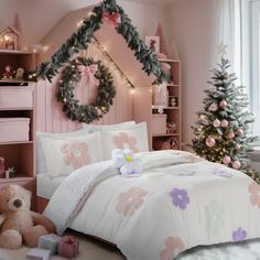 a bedroom decorated for christmas with pink and white bedding, teddy bear and tree