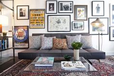 a living room with pictures on the wall and a couch in front of a coffee table