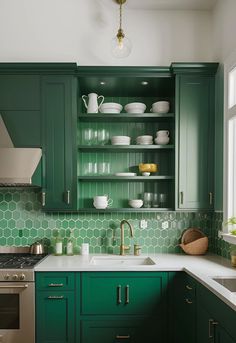 a kitchen with green cabinetry and white counter tops in the center, along with an oven