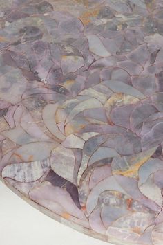 a close up of a marble table top with rocks and leaves on it's surface