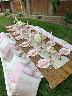 a table set up with pink and white plates