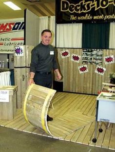 a man standing in front of a display with wood planks on the floor and walls