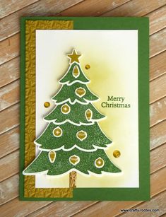 a christmas card with a green tree on the front and gold stars on the back