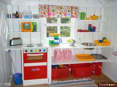 a play kitchen with red and white appliances