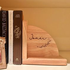 two books are sitting next to each other on a shelf with a wooden bookend