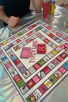 a man sitting at a table with a monopoly board game on it's surface