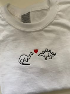 Dinosaur Embroidered T-shirt  Sizing Tees are unisex so have a slightly oversized look on women, go down a size for a slimmer fit. Small- 8/10 Medium- 10/12 Large- 12/14 Extra Large 14/16 100% Cotton Embroided T Shirts, Embroidery On T Shirt, Dinosaur Clothes Women, Embroidery Shirt Designs, Tshirt Motive, Embroidery Tshirt Dinosaur, Taylor Embroidery, Dinosaurs In Love, Dino Tshirt