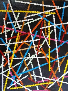 an abstract painting with colored lines and dots on black paper, in the shape of letters