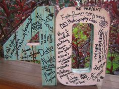 a wooden sign with writing on it sitting in front of a tree and some bushes