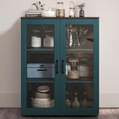 a blue cabinet with glass doors and dishes on top