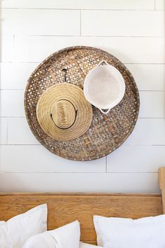 two hats hanging on the wall above a bed