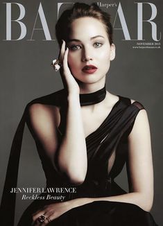 a woman in a black dress posing with her hand on her face and wearing a choker