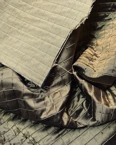 an unmade bedspread is laying on top of another bed with two pillows