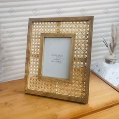 an ornate gold frame with a quote on it sitting on a table next to a vase