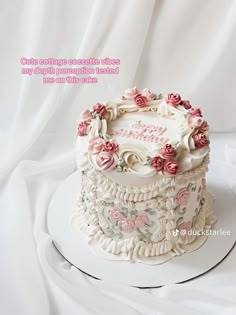 there is a white cake with pink flowers on the top and words written in english