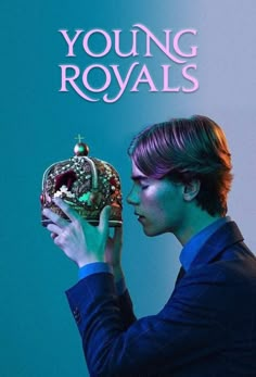 a young man holding a crown in front of a blue background with the words young royals on it