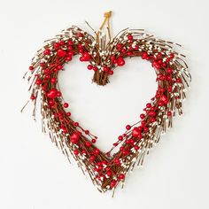 a heart shaped wreath with red berries and brown twigs in the shape of a heart