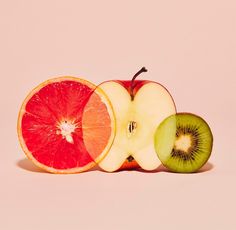 an apple, orange and grapefruit cut in half