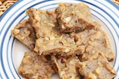 some brownies on a blue and white plate topped with peanut butter bars covered in caramel glaze