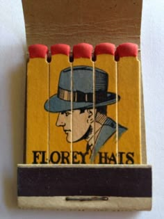 a matchbox with matches in the shape of a man's hat and four matches