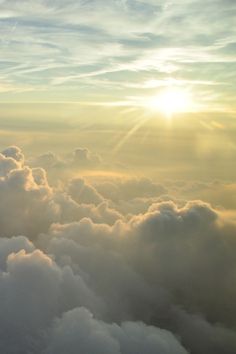 the sun shines through clouds as seen from an airplane