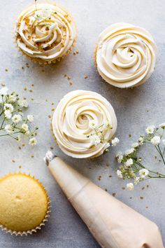 three cupcakes with white frosting and flowers