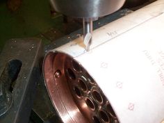 a machine that is cutting some paper with it's blades on the table and another piece of metal in front of it