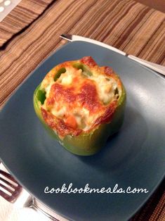 a green pepper stuffed with cheese on a blue plate