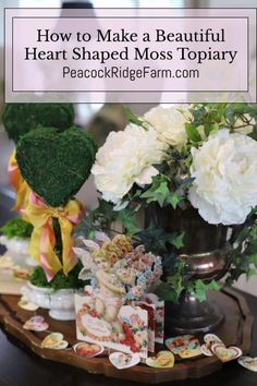 a wooden tray topped with lots of flowers next to a vase filled with white flowers