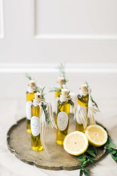 three bottles of olive oil with lemons on a tray