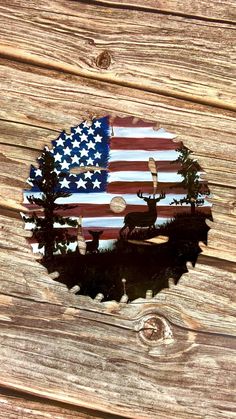 an american flag is reflected in a bottle cap on a wooden surface with pine trees