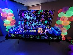 an image of a birthday party setting with balloons and streamers on the table at night