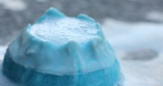 a blue and white cake sitting on top of a table covered in frosted icing