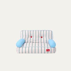 a blue and white striped couch sitting on top of a white floor next to a wall