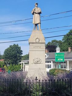 a statue of a man standing on top of a cement block with power lines in the background