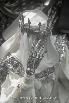 a white veil and crown on top of a headdress with silver decorations around it