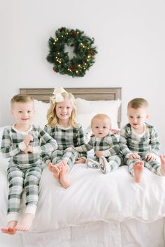 three children are sitting on a bed together