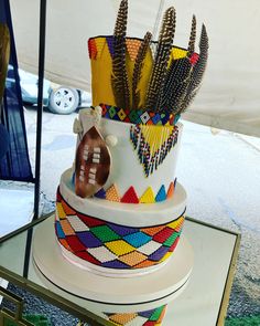 a multicolored cake with football and feathers on it