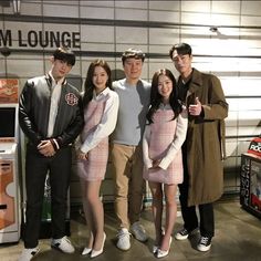 a group of people standing next to each other in front of a vending machine